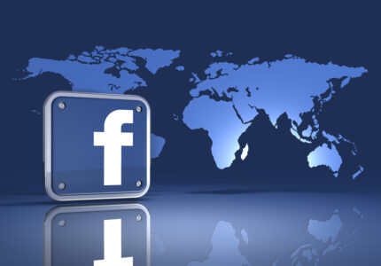 3d illustration of a facebook logo standing in front of an upright map of the world on a blue reflective surface